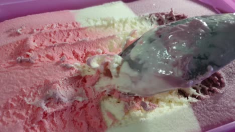 helado a rayas con tema de barbie con sabor a fresa, vainilla y corriente negra en tina rosa, delicioso postre dominical servido con una cuchara de acero inoxidable