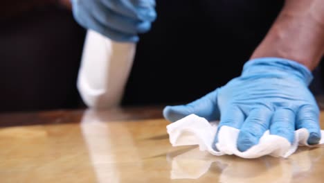 cleaning a surface with gloves and a cloth