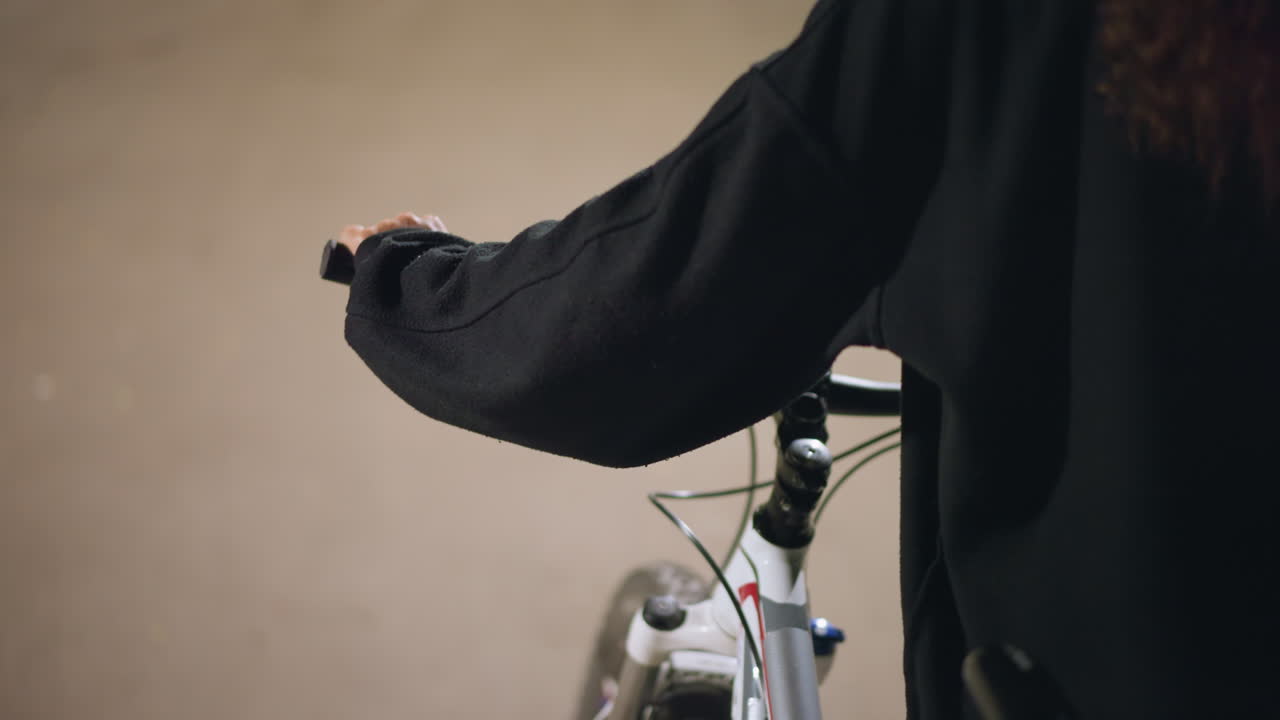 Individual Leisurely Cycling Along Pathway, Relaxed Person Pushing Bicycle During Peaceful Outdoor Walk, Solitary Cyclist Strolling On Scenic Route Wearing Casual Jacket In Afternoon