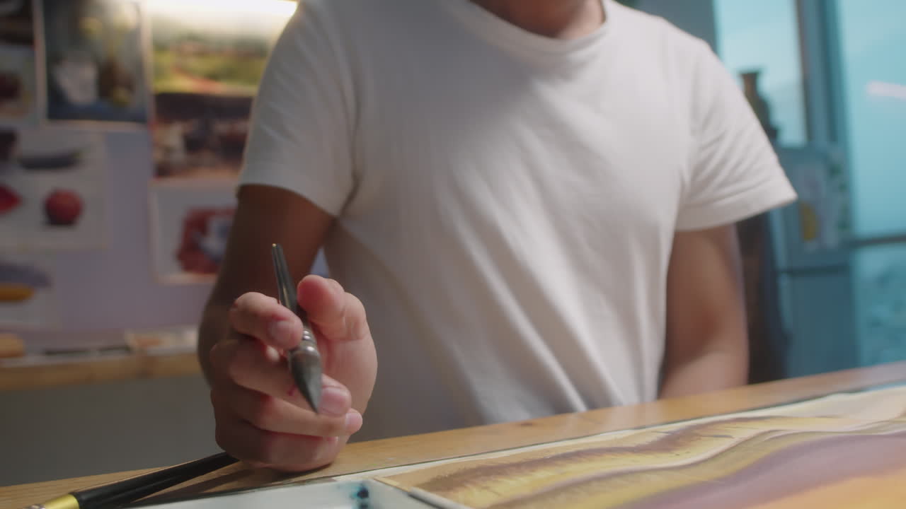 Painter Drawing on Paper at Desk