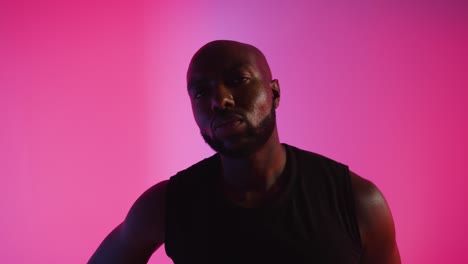 Close-Up-Studio-Portrait-Of-Male-Basketball-Player-Dribbling-And-Bouncing-Ball-Against-Pink-Lit-Background-1