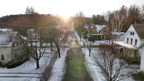 Lento-Carro-Aéreo-Hacia-Adelante-Hacia-El-Sol-Brillante-Y-Cálido-En-Un-Barrio-Cubierto-De-Nieve-En-Estados-Unidos