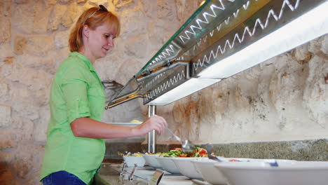 Mujer-Elige-Verduras-En-Un-Café-Con-Autoservicio