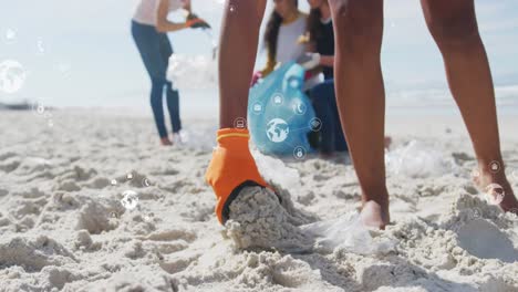 Animation-of-globe-icons-over-hand-of-biracial-female-volunteer-picking-up-rubbish-on-beach