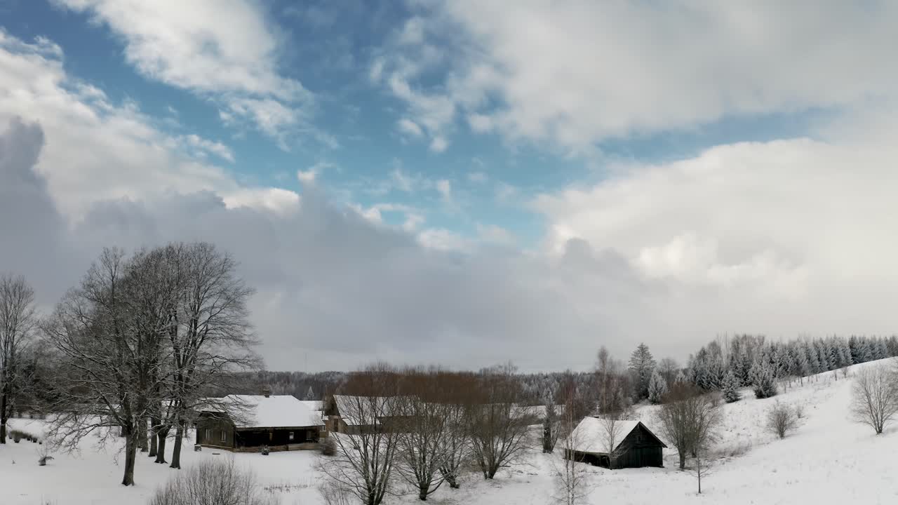 Aerial view of a guesthouse in the countryside during winter with lots of snow and frost on the trees. Winter wonderland in historic suburb area on a bright and sunny winter day. Frozen forest.