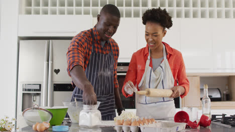 Video-of-happy-african-american-couple-baking-together-in-kitchen