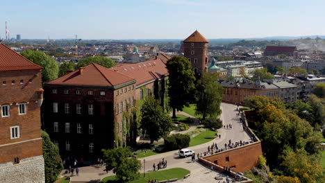 Drone-footage-of-Wawel-Royal-Castle-with-tourists,-Krakow,-Poland