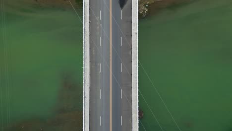 top down tracking along santo domingo bridge crossing water in virac, catanduanes, vehicle drive along road