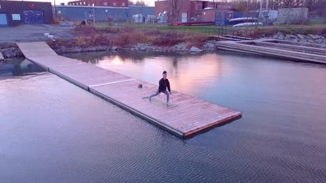 aerial view of a woman doing yoga on a dock