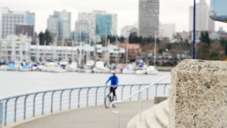 man riding a bike on the promenade near the harbor 4k