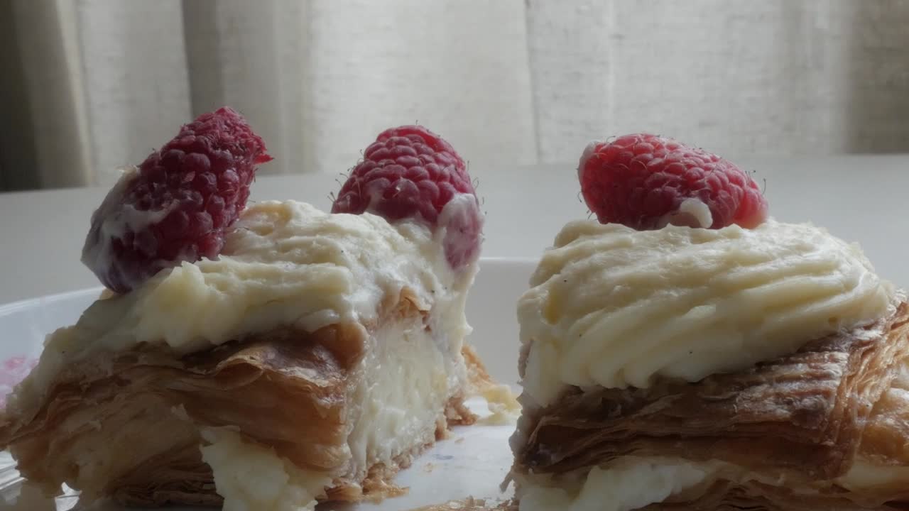 Raspberry pastries with cream in soft daylight, cozy and delicious mood