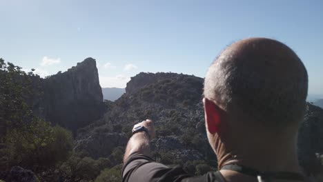 Hombre-Apuntando-A-La-Formación-Rocosa-De-La-Montaña-Salto-De-Cabrero-En-Grazalema,-España,-Cámara-Lenta