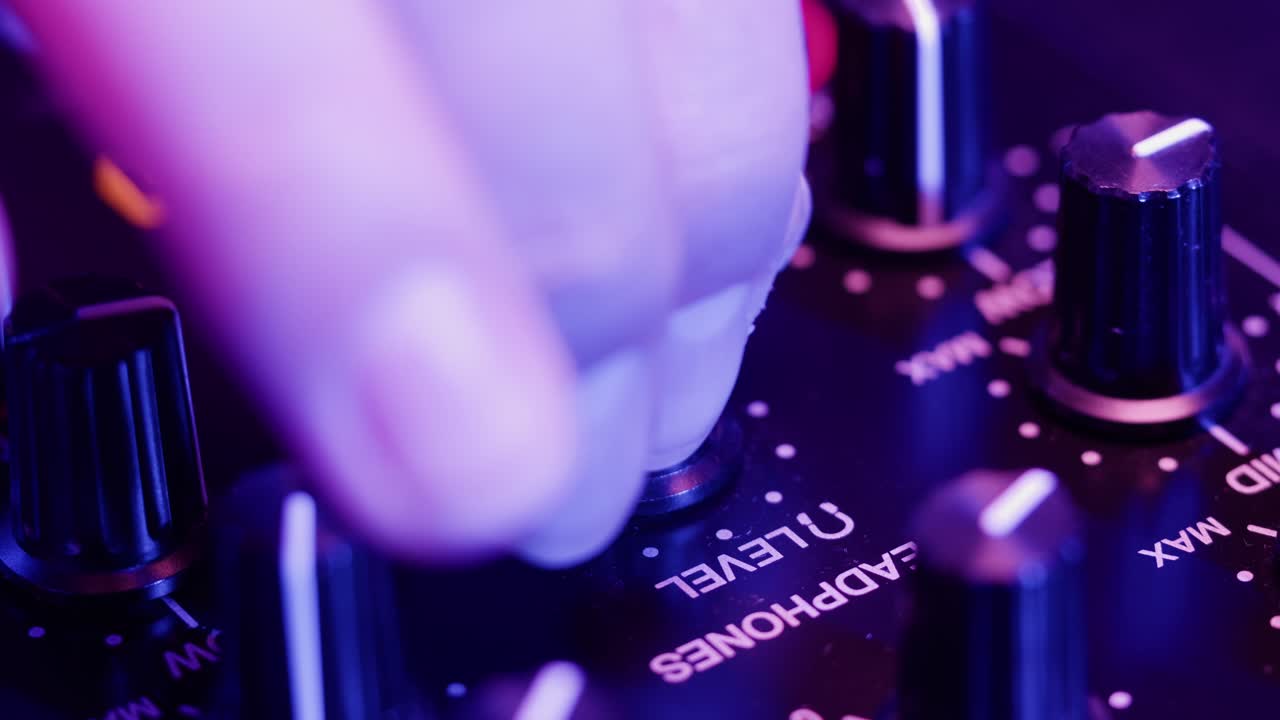 DJ with headphones and sunglasses playing music on festival in night club. Techno musician performing at nightclub for concert crowd of people, city bar.