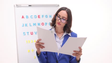 professional woman teacher reviewing documents in a classroom
