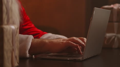 Papá-Noel-Responde-El-Correo-Electrónico-Del-Niño.-Escribiendo-En-El-Teclado-Del-Portátil.-Las-Manos-De-Papá-Noel-Se-Cierran.-Imágenes-4k-De-Alta-Calidad