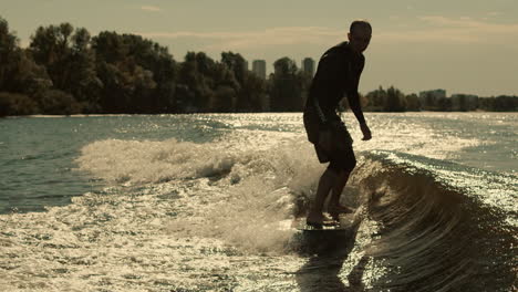 man surfing on waves. sportive man surfing on wakeboard in slow motion