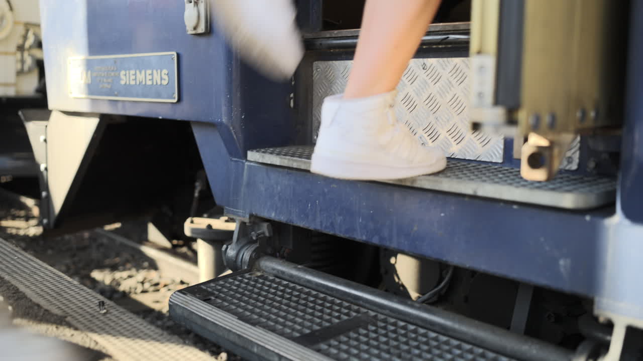 tiros baixos ao solo de passageiros entrando em um trem em uma estação através de degraus