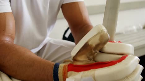 cricket player sitting on bench in dressing room