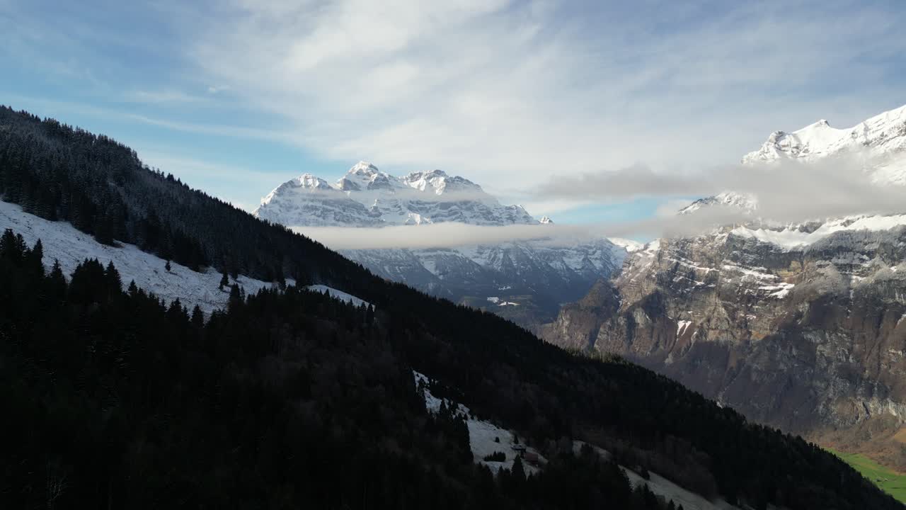 lado de la montaña boscosa oscura en la sombra con bandas de nubes en capas sentadas debajo de la montaña suiza