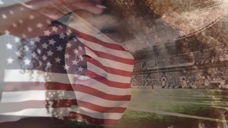 Animation-of-flag-of-united-states-of-america-over-african-american-woman-and-sports-stadium