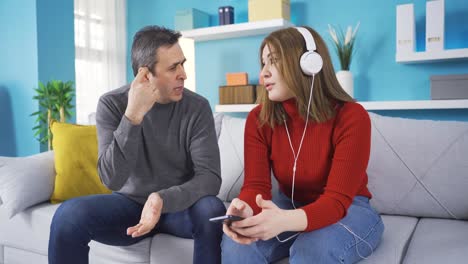 padre advirtiendo a su hija que usa su teléfono excesivamente.