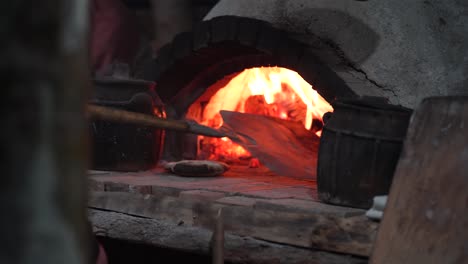 Traditionelles-Brotbacken:-Altmodischer-Ofen,-Holzfeuer,-Gebogener-Stein,-Ein-Altehrwürdiges-Kulinarisches-Handwerk,-Das-Den-Duft-Hausgemachter-Köstlichkeiten-Freisetzt