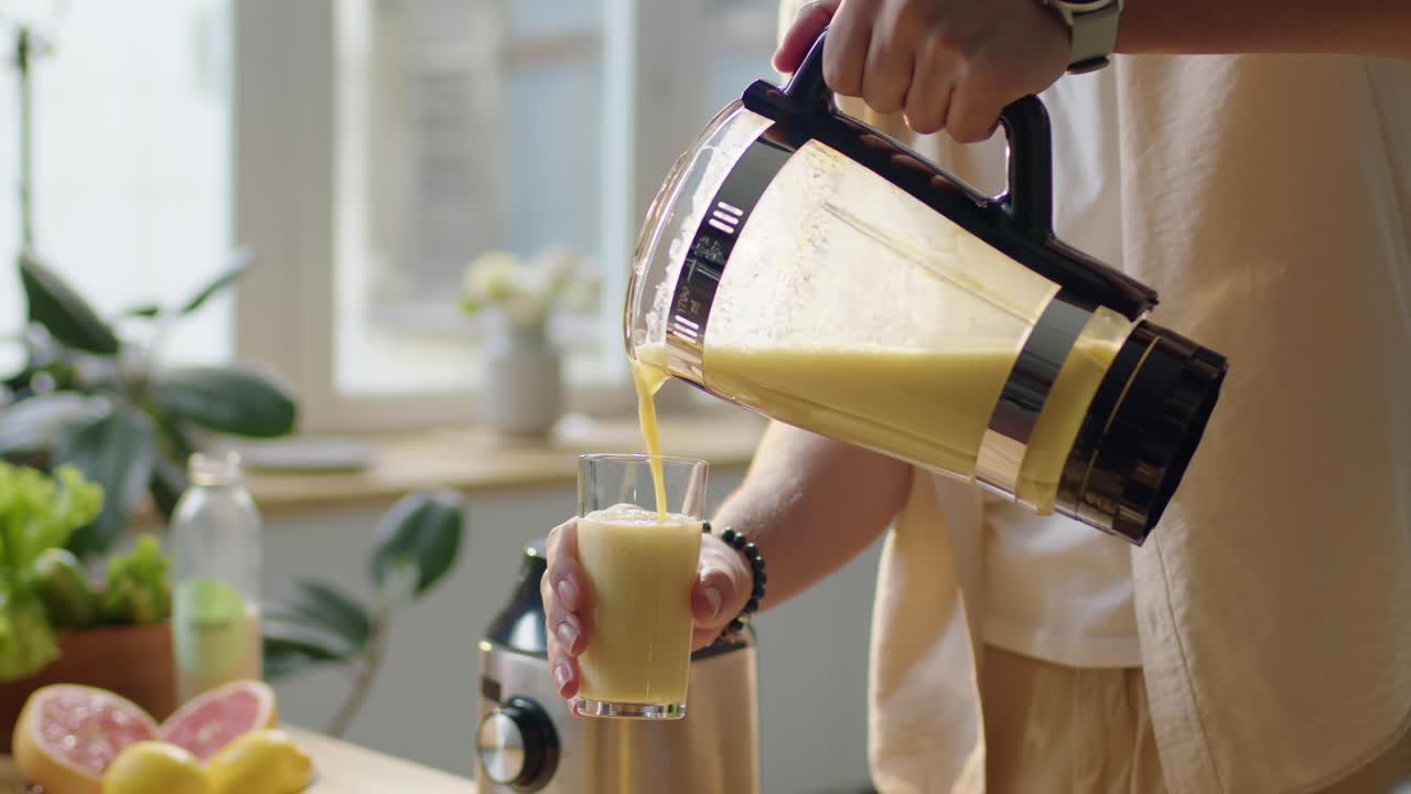 Man Pouring Fruit Smoothie in Glass
