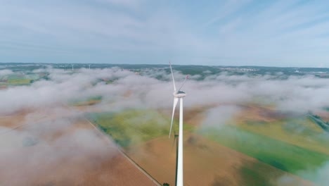 Wind-turbine-above-the-clouds-in-a-field-aerial