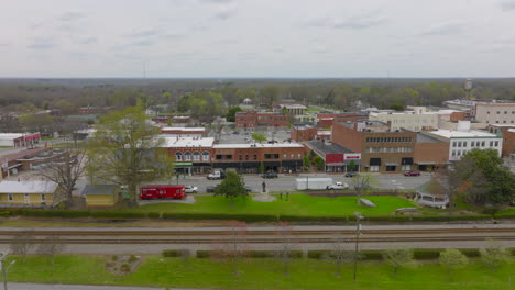 Push-over-train-tracks-and-towards-retail-shops-on-main-street-in-Thomasville,-North-Carolina-on-a-cloudy-day