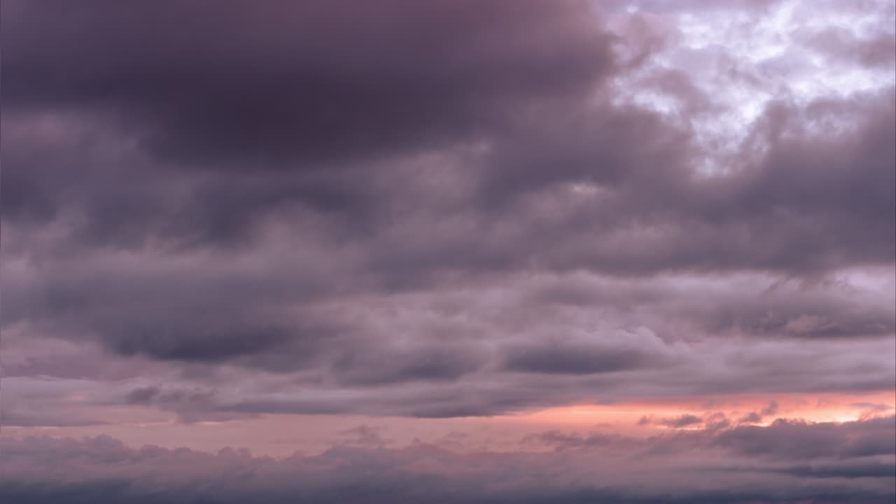 일몰 하늘: 오렌지 색의 파스텔 색의 효과와 함께 지평선 위에 서식 하늘에 움직이는 무거운 회색과 보라색의 비구름.