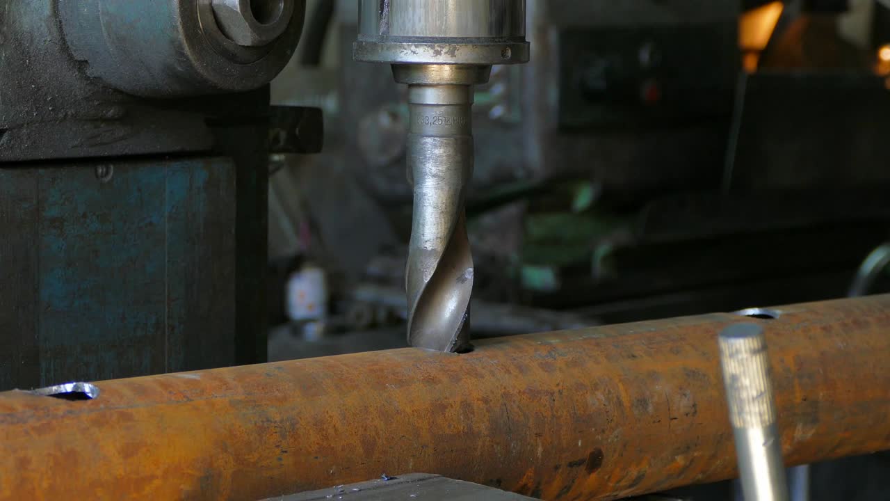 기계 운영자는 비스에 파이프를 고정하고 구을 기 시작했습니다.