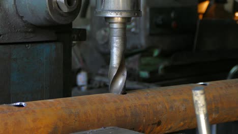 el operador de la máquina sujetó el tubo en el tornillo y comenzó a perforar agujeros