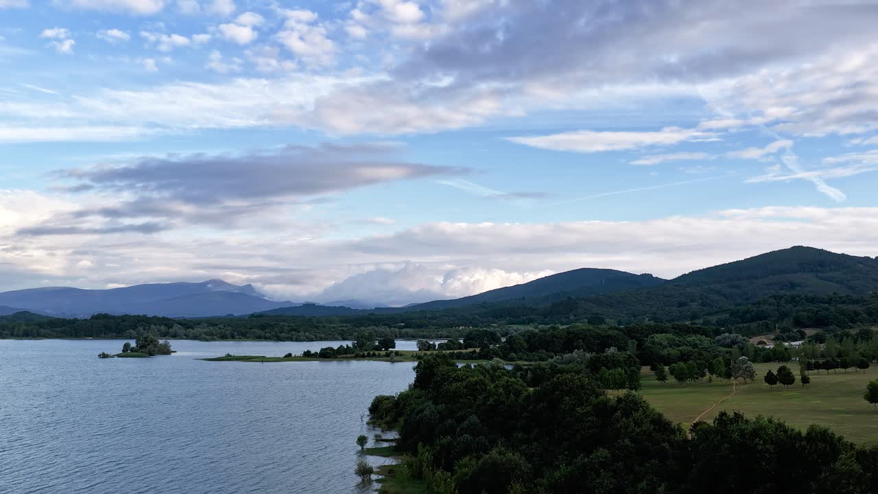 Scenic aerial view of a lake with mountains and cloudy sky