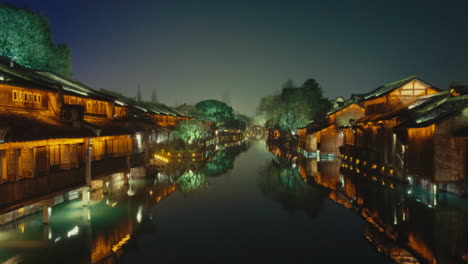 a scenic view of wuzhen, china at night, showcasing its illuminated canals and traditional architecture