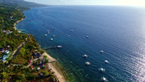 Amazing-panoramic-shot-of-picture-postcard-view-of-of-shoreline,-beaches,-curb-highway-along-hillside,-greeny-mountains-and-the-beautiful-blue-sea-water-where-boats-floating-close-to-the-seashore