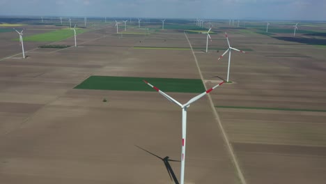 aerial view of several windmills, wind generators, turbines, producing renewable clean energy by converting kinetic energy