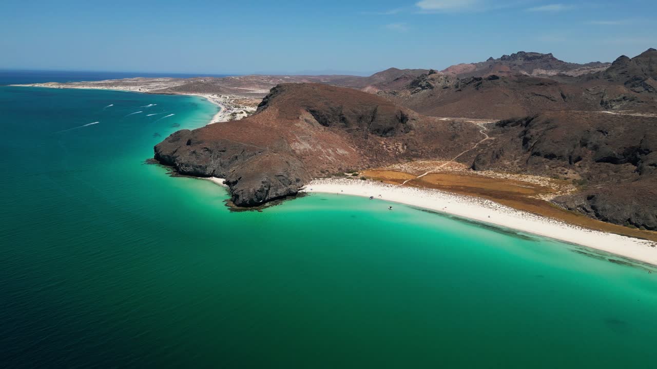 Crystal-clear beach waters meet rugged desert cliffs in Tecolandra, La Paz