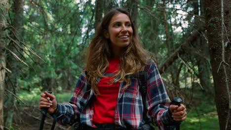 senderista sonriente caminando en el bosque verde