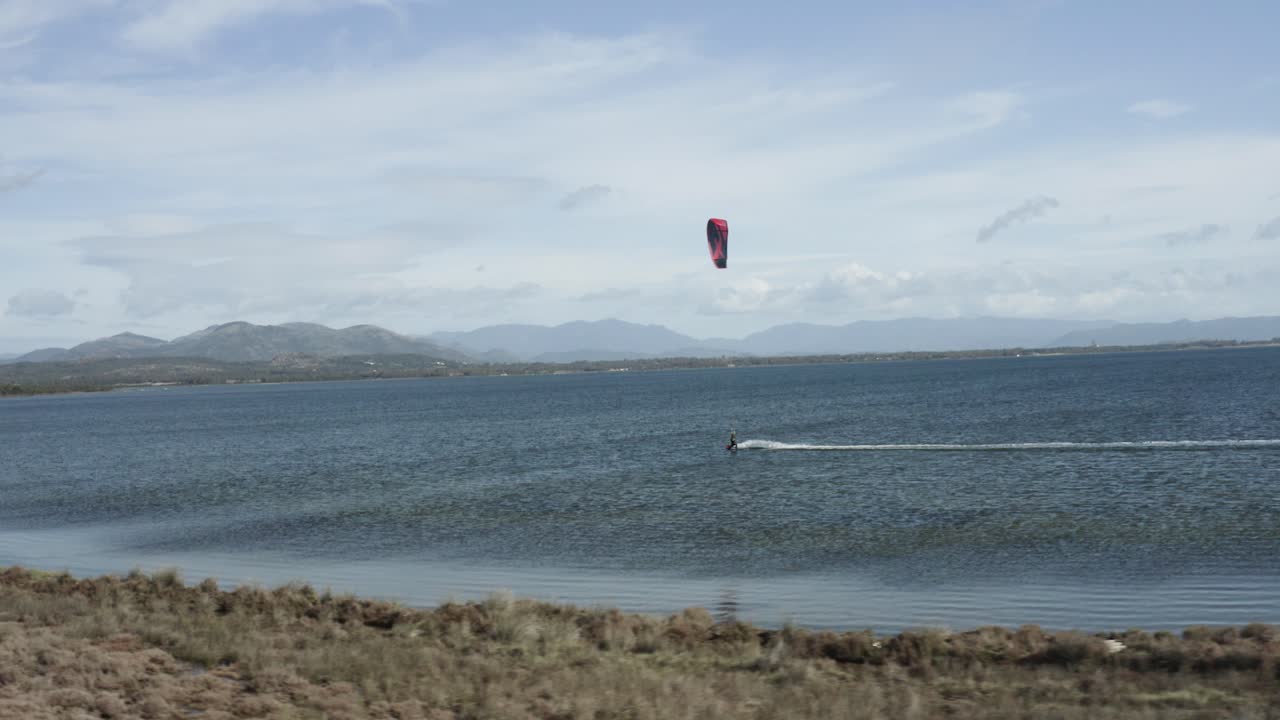 kitesurf - vista aérea de kiteboarder divirtiéndose en el agua en cerdeña