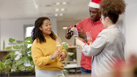 casual diverse businesspeople drinking champagne at christmas in office, slow motion