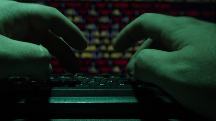 Mani che digitano su una tastiera in un ambiente buio