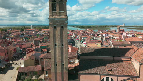 vista aérea de burano, venecia, mostrando los vibrantes colores de las casas, el histórico campanario y la laguna circundante.