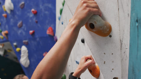 Cerca-De-Una-Mujer-Caucásica-Trepando-Por-Una-Pared-En-El-Muro-De-Escalada-Interior