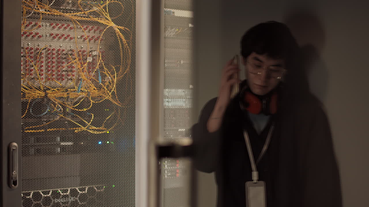 Asian IT Specialist Making Telephone Call in Data Center