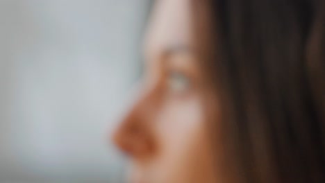 Close-up-rack-focus-of-caucasian-brunette-female-eyes-look-outside-window