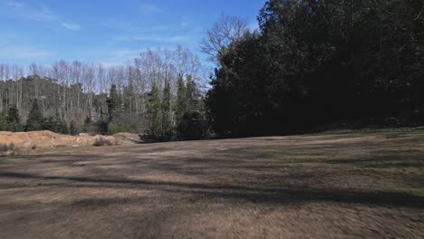 drone fly low close to hiking trail meadow grass field surface, european winter