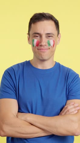 man standing with italian flag painted on face smiling