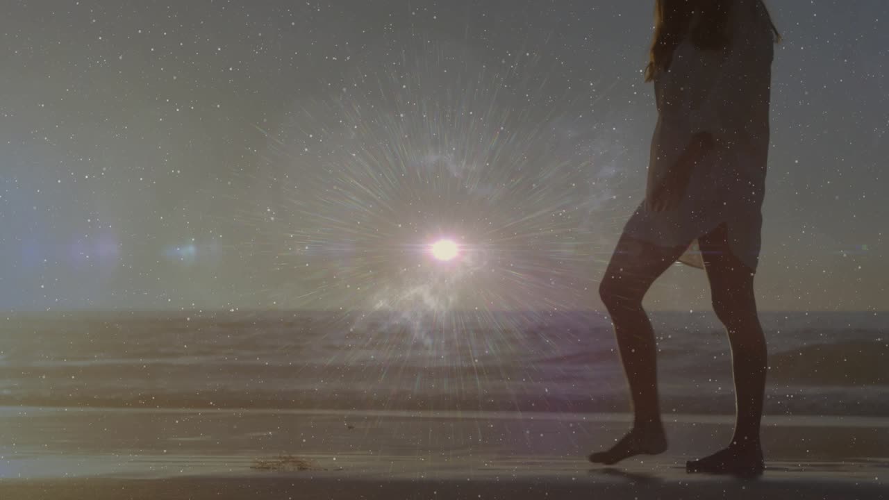 Sunset light causing woman walking shoreline bending silhouette lifting pebble in travel promo