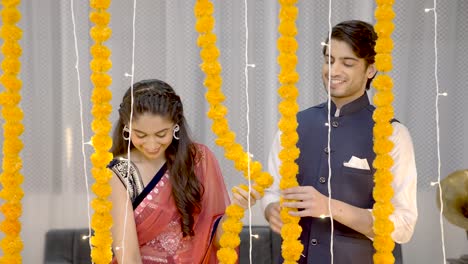 una linda pareja india decorando su casa para diwali