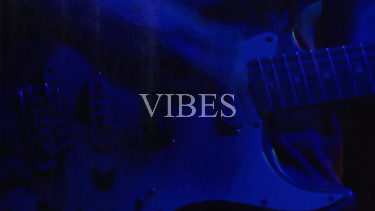 Animazione del testo "Belle vibrazioni" su una persona che suona la chitarra